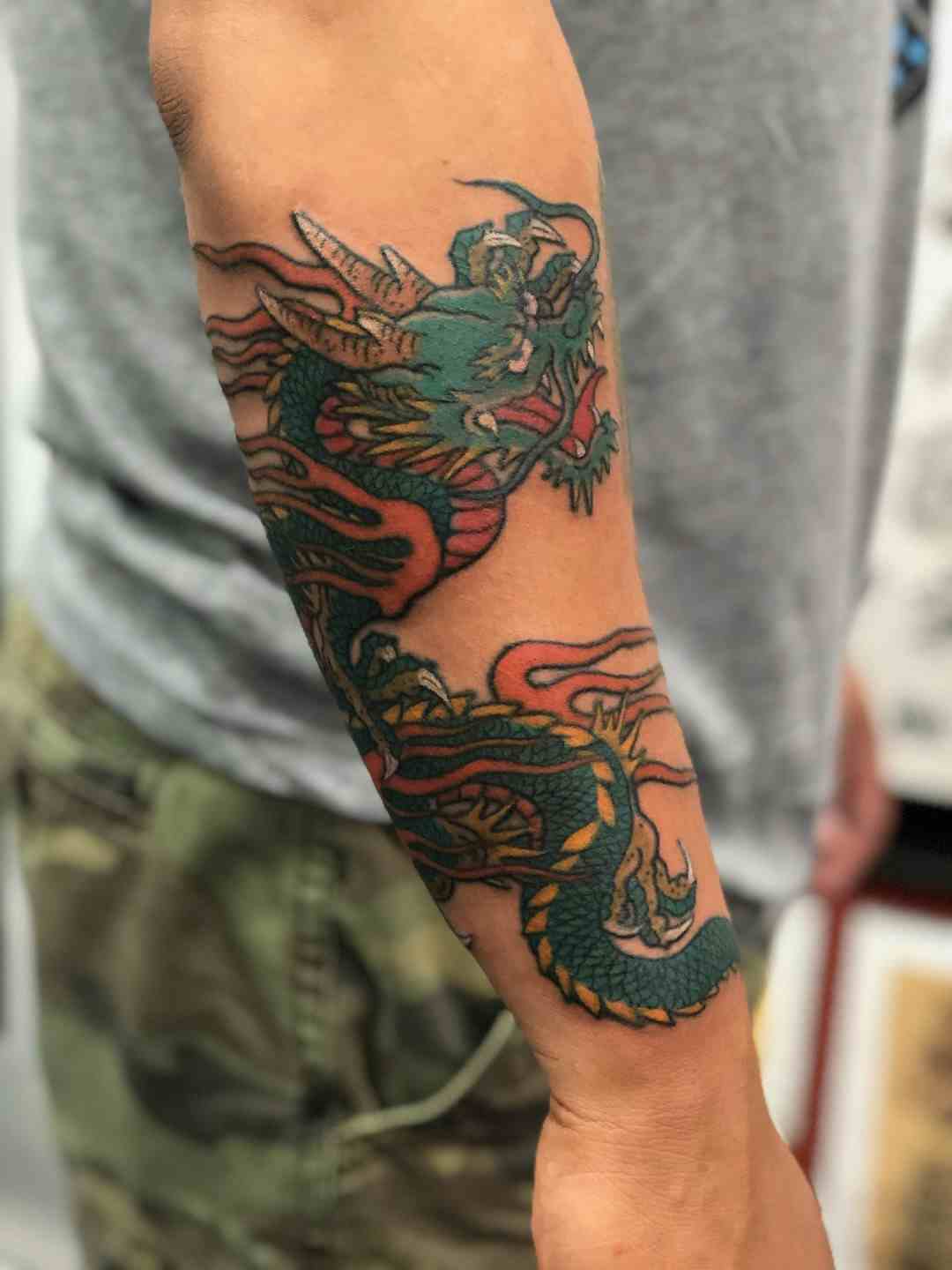 Flying dragon forearm tattoo