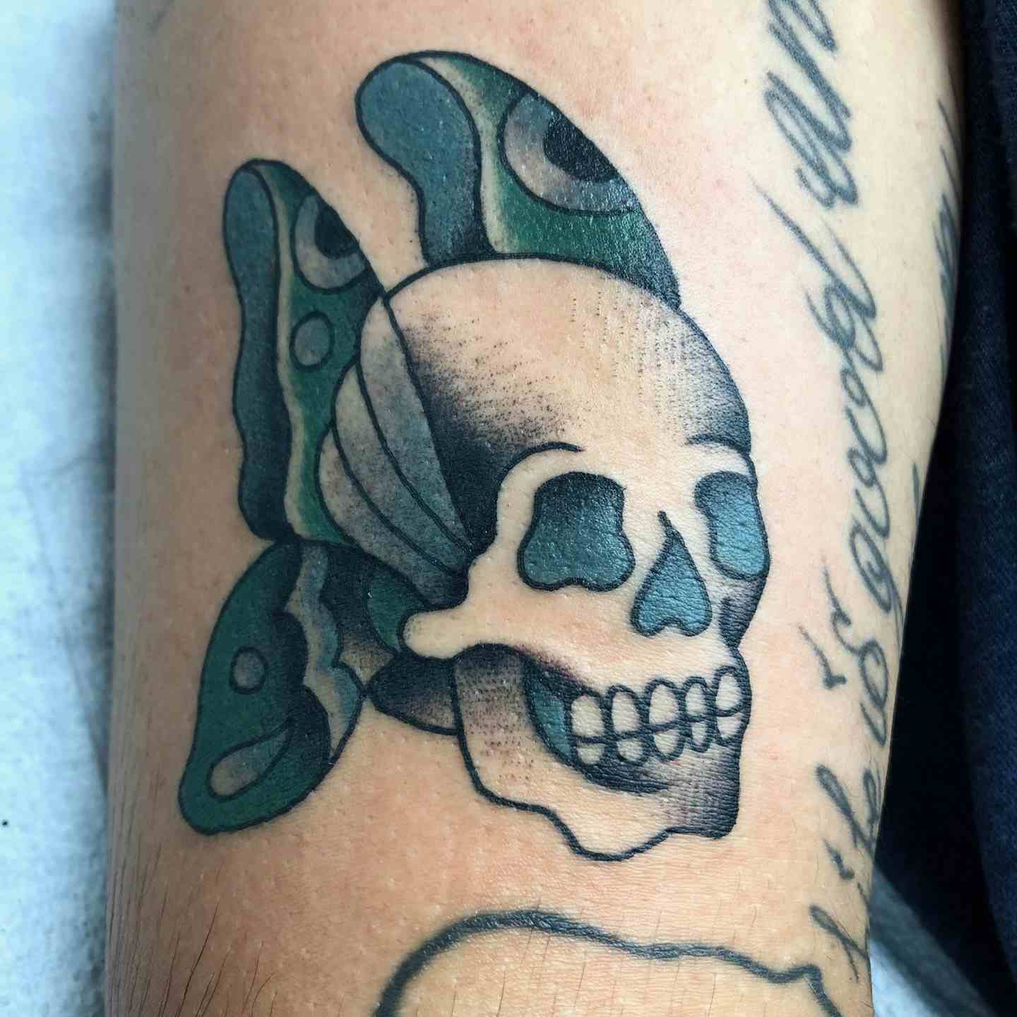 Green butterfly skull tattoo