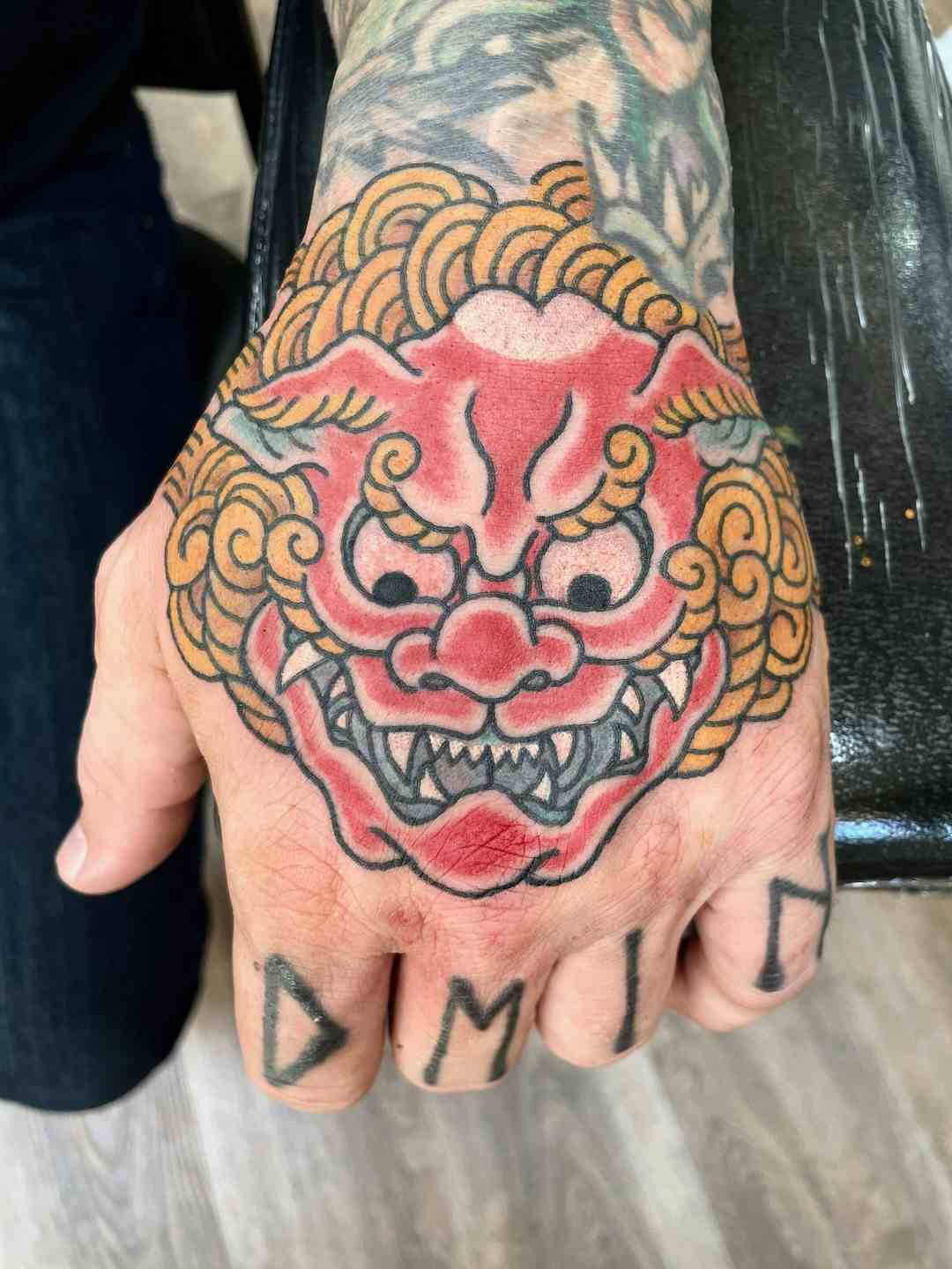 Red chinese snow lion foo dog hand tattoo