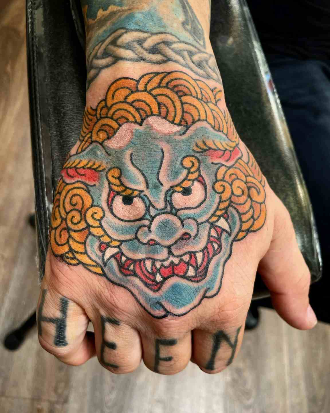Blue chinese snow lion foo dog hand tattoo