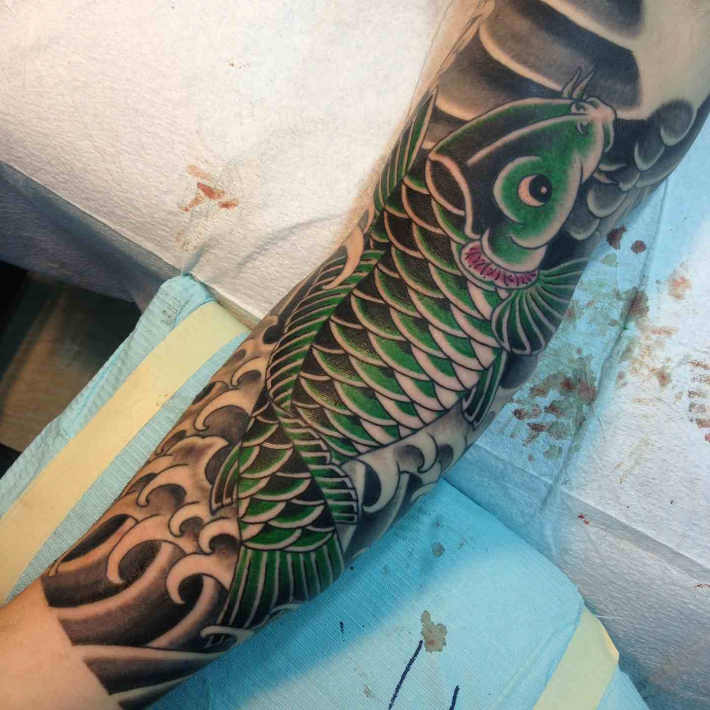Green koi fish sleeve tattoo
