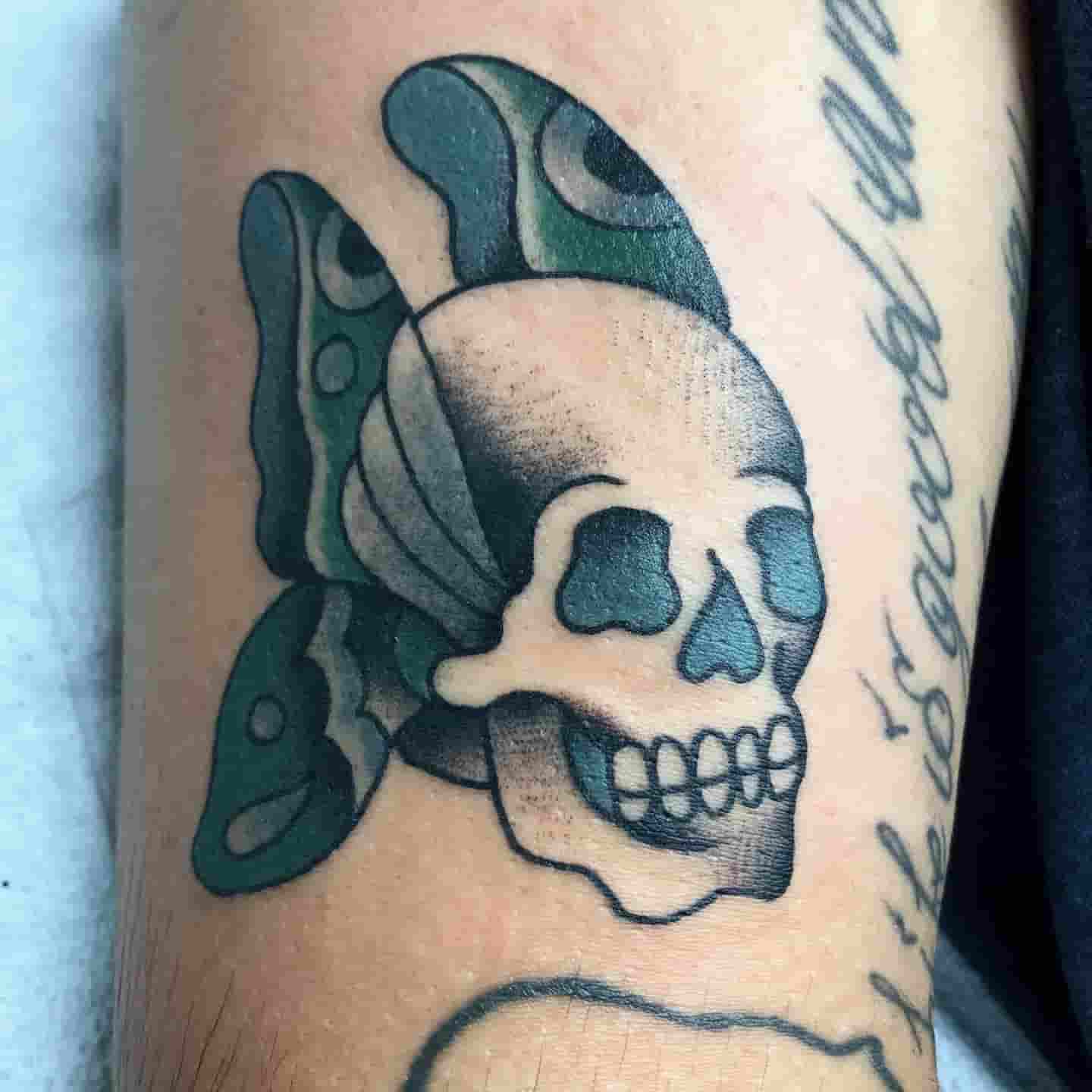 Green butterfly skull tattoo